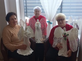 Zdjęcie przedstawia trzy osoby z efekatmi pracy w postaci aniołów wykonanych z materiałów z recyklingu